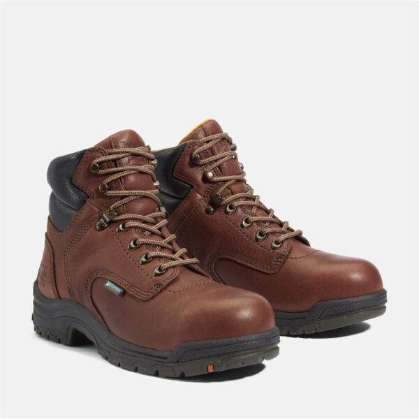 A turned pair of Timberland TiTAN alloy toe 6-inch waterproof women's work boots in brown with a blank background.