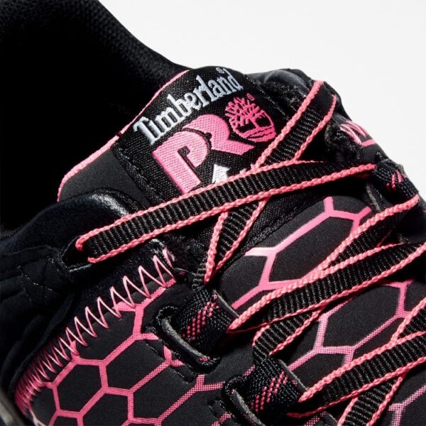 Close up of Timberland PRO Powertrain Sport alloy toe women's work sneakers in black and pink showing anti-fatigue technology tag with a blank background.