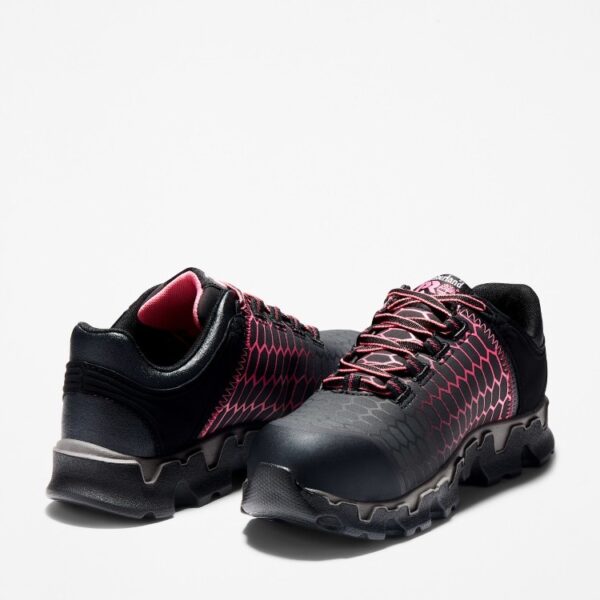Offset pair of Timberland PRO Powertrain Sport alloy toe women's work sneakers in black and pink with a blank background.