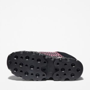 The sole of the right boot on a Timberland PRO Powertrain Sport alloy toe women's work sneakers in black and pink with a blank background.