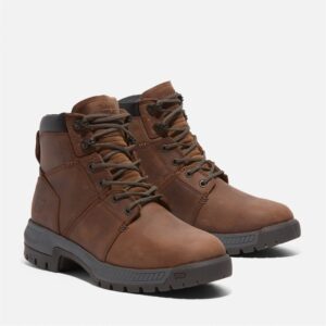 A turned pair of Timberland Montauk soft toe men's 6-inch work boots in brown with a blank background.