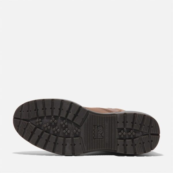 The sole of the right boot on a Timberland Montauk soft toe men's 6-inch work boots in brown with a blank background.