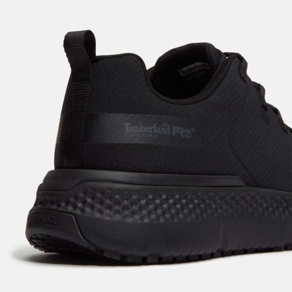 Close up of Timberland Power Shift soft toe men's hospitality work sneaker in black showing slip-resistant stamp and with a blank background.