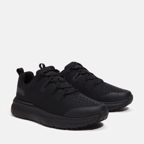 A turned pair of Timberland Power Shift soft toe hospitality men's work sneakers in black with a blank background.