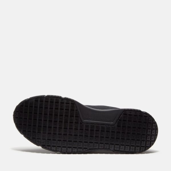 The sole of the right boot on a Timberland Power Shift soft toe hospitality men's work sneaker in black with a blank background.