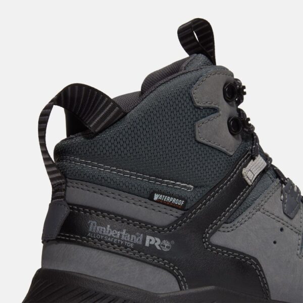 Close up of Timberland Tempe safety toe men's work boots in gray showing alloy toe stamp and waterproof tag with a blank background.