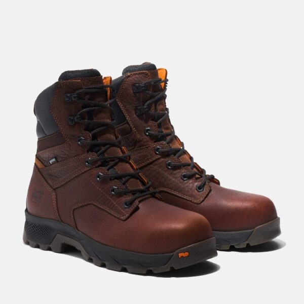 A turned pair of Timberland TiTAN EV composite toe waterproof men's 8-inch work boots in brown with a blank background.