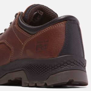Close up of Timberland TiTAN EV safety toe men's Oxford work shoe in brown showing composite toe stamp with a blank background.