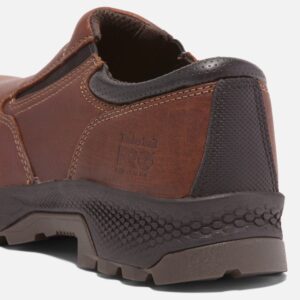 Close up of Timberland TiTAN EV safety toe men's slip-on work shoe in brown showing composite toe stamp with a blank background.