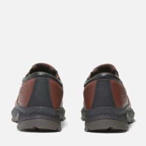 A look at the heels of a pair of Timberland TiTAN EV composite toe men's slip-on work sneakers in brown with a blank background.