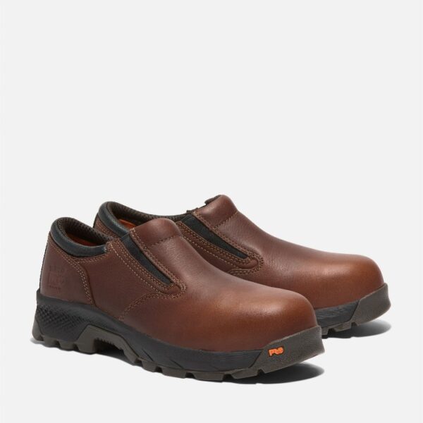 A turned pair of Timberland TiTAN EV composite toe men's slip-on work shoes in brown with a blank background.