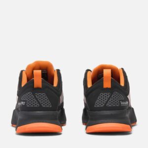 A look at the heels of a pair of Timberland PRO Powertrain composite toe men's athletic work sneakers in black and orange with a blank background.