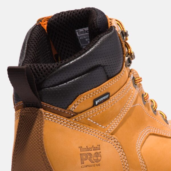 Close up of Timberland PRO TiTAN EV safety toe men's waterproof 6-inch work boot in wheat showing composite toe stamp and waterproof tag with a blank background.