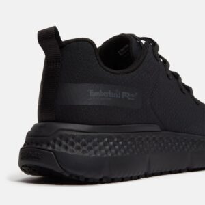 Close up of Timberland Power Shift soft toe women's hospitality work sneaker in black showing slip-resistant stamp and with a blank background.