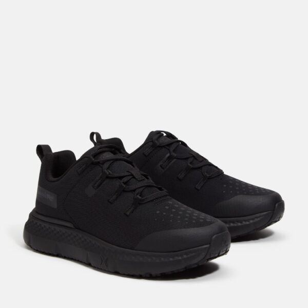A turned pair of Timberland Power Shift soft toe hospitality women's work sneakers in black with a blank background.