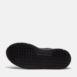 The sole of the right boot on a Timberland Power Shift soft toe hospitality women's work sneaker in black with a blank background.