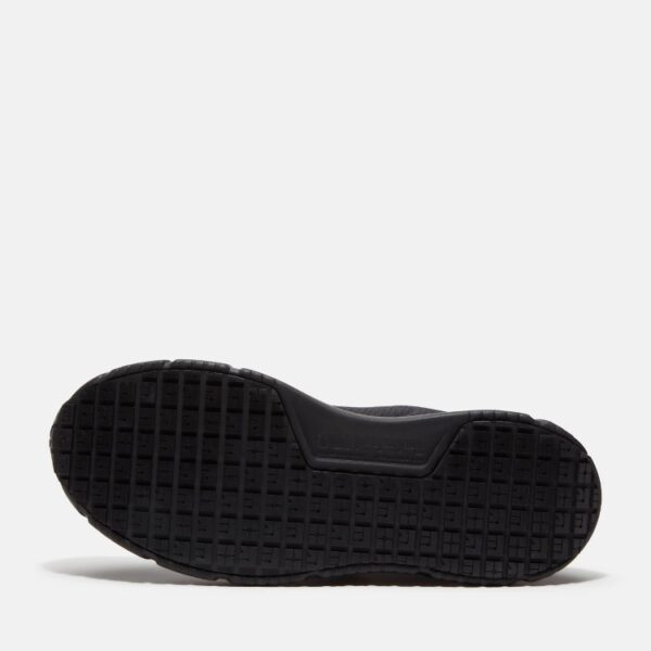The sole of the right boot on a Timberland Power Shift soft toe hospitality women's work sneaker in black with a blank background.