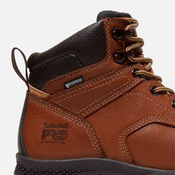 Close up of Timberland TiTAN EV safety toe women's 6-inch waterproof work boot in brown showing composite toe stamp with a blank background.