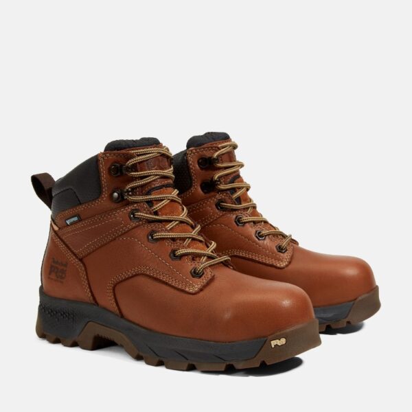 A turned pair of Timberland TiTAN EV composite toe waterproof women's 6-inch work boots in brown with a blank background.