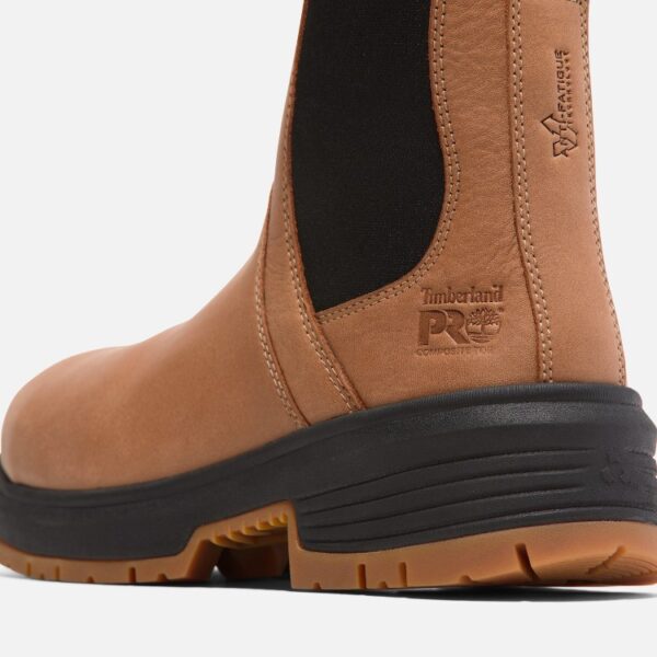 Close up of Timberland PRO Birchline safety toe women's 6-inch pull-on work boot in tan showing composite toe stamp with a blank background.