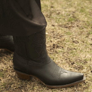 A lifestyle image of a Corral Black Embroidered Snip Toe Western Ankle Boot.