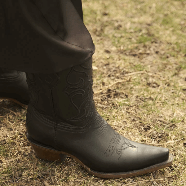 A lifestyle image of a Corral Black Embroidered Snip Toe Western Ankle Boot.