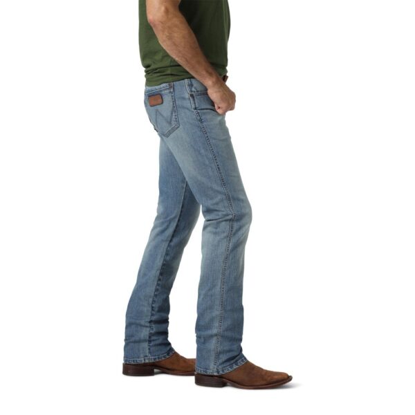 A modeled, side-facing look at a pair of Wrangler Men's Retro Slim Fit Straight Leg Jeans.